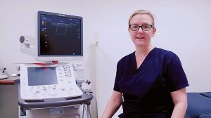 A sonographer sitting next to a duplex ultrasound.