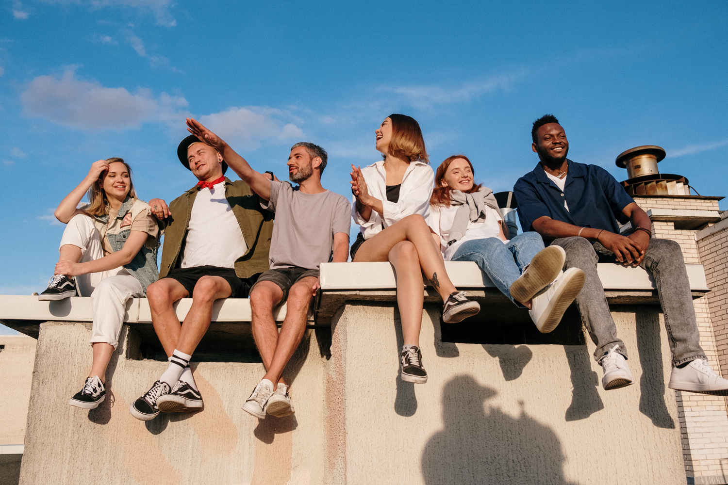 A group of young people sitting on top of a roof.